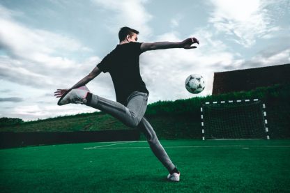 man playing soccer during daytime